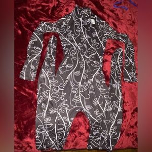 Black jumpsuit with feet and white lines/faces .